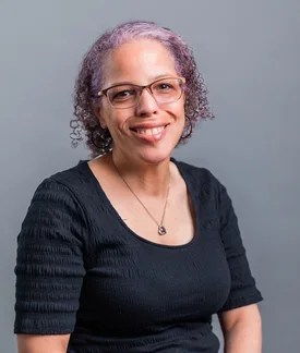 Kat Shaw smiling wearing glasses and a black shirt