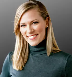 Woman with blonde hair wearing a gray turtleneck.