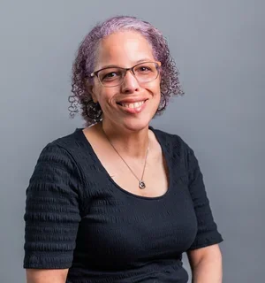 Kat Shaw smiling wearing glasses and a black shirt