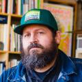 Aaron Draplin wearing a green trucker hat