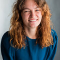 A woman wearing a green top with curly hair