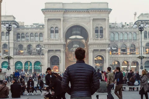 People standing in the courtyard in front of a building.